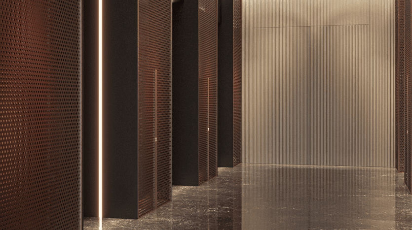 Un couloir moderne faiblement éclairé avec des panneaux métalliques sombres texturés et des bandes lumineuses verticales sur la gauche, menant directement devant une porte d'ascenseur simple et réfléchissante dans un appartement de Dubaï.
