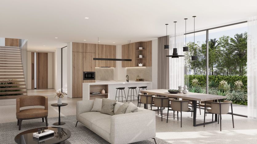 Espace de vie moderne et décloisonné avec cuisine, salle à manger et espace de vie dans une villa à Dubaï menant à un jardin par des portes vitrées du sol au plafond. Un mobilier contemporain et des tons neutres créent un espace élégant et