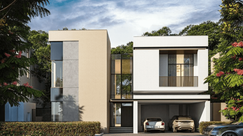 Villa moderne de deux étages à Dubaï avec un toit plat, dotée de grandes fenêtres et d'un design minimaliste, entourée d'une verdure luxuriante et d'arbres en fleurs. Deux voitures sont garées sous une allée couverte.