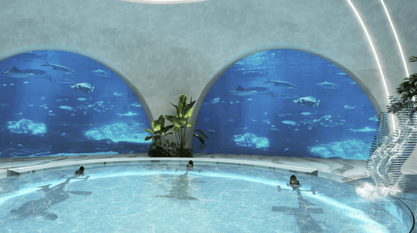 Une piscine intérieure avec des gens profitant de l'eau, entourée de grandes fenêtres avec vue sur l'aquarium montrant diverses créatures marines nageant, sous des arches courbes et modernes et une pièce maîtresse botanique dans une luxueuse villa à Dubaï.