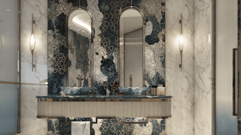Salle de bains luxueuse dans un appartement de Dubaï comprenant une double vasque avec des lavabos bleu sarcelle uniques, des miroirs ornés et un mur décoratif en mosaïque dans les tons bleu et or. Un éclairage chaleureux et des détails en marbre améliorent l'opération
