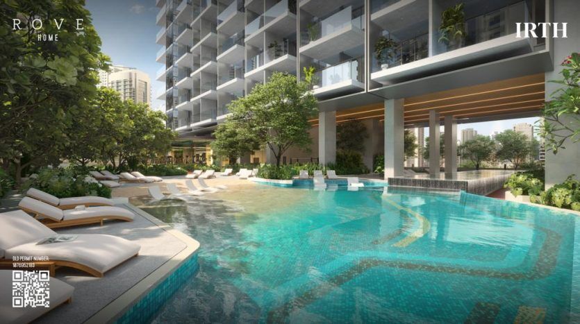 Une luxueuse piscine extérieure dotée d'une eau bleu clair entourée de chaises longues, bordée de plantes vertes luxuriantes et surplombée par des immeubles d'appartements modernes à plusieurs étages à Dubaï.