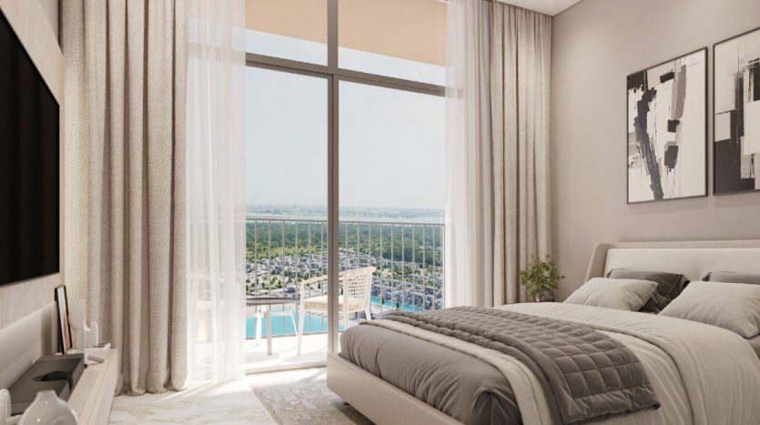 Chambre moderne avec une grande fenêtre donnant sur un paysage urbain, comprenant un lit soigneusement fait, une table d'appoint avec une lampe, une décoration subtile et des œuvres d'art murales encadrées. Des rideaux légers et aérés encadrent la vue sur le