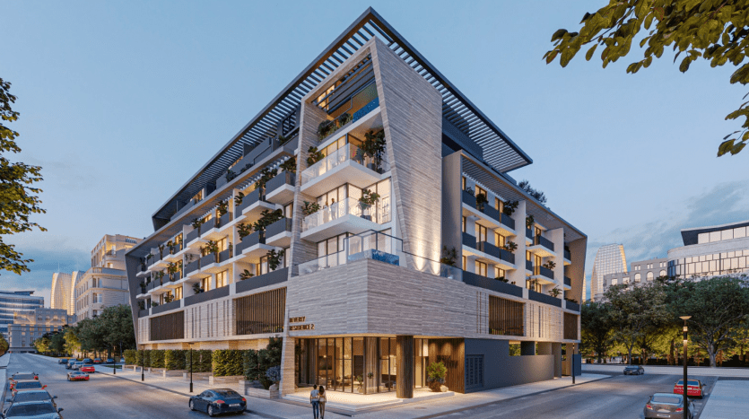 Bâtiment résidentiel et commercial moderne de plusieurs étages à Dubaï, illuminé au crépuscule, doté d'une combinaison de balcons en verre, de boiseries et d'avant-toits en surplomb proéminents, situé dans une rue bordée d'arbres.