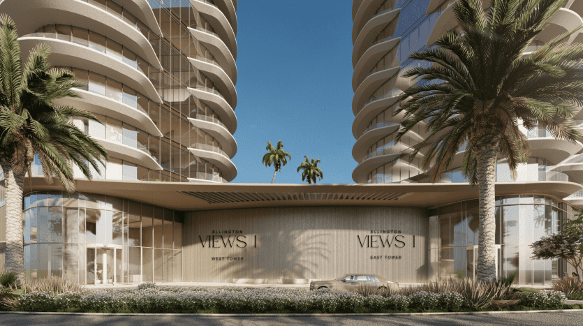Architecture urbaine moderne composée de deux immeubles de grande hauteur flanqués de palmiers, centrés autour d'une entrée intitulée « Ellington Views | East Tower » dans l'immobilier Dubaï. Une journée ensoleillée améliore le cadre serein.