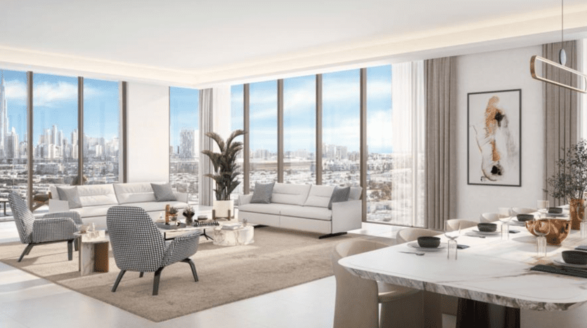 Un salon moderne et lumineux dans un appartement de Dubaï avec de grandes fenêtres mettant en valeur les toits de la ville. Meublé avec des canapés blancs, une table ronde et orné d'œuvres d'art encadrées, de plantes et d'un décor subtil.