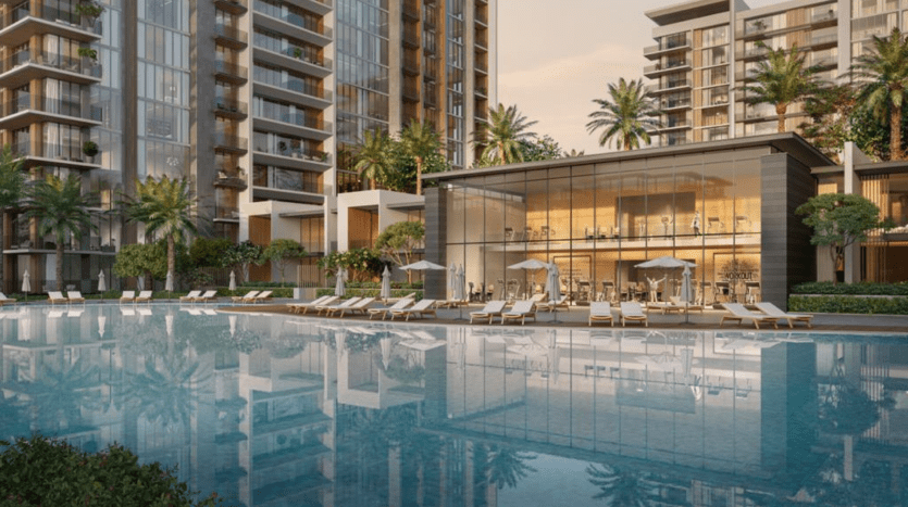 Piscine luxueuse de style complexe avec eau réfléchissante au premier plan, entourée de chaises longues et de grands parasols. Des immeubles de grande hauteur modernes avec une verdure luxuriante encadrent la zone de la piscine, idéal pour l'immobilier Dubaï