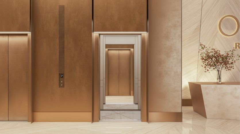 Un hall d'entrée d'hôtel moderne avec des portes d'ascenseur élégantes et dorées s'ouvre, révélant un intérieur en marbre qui ressemble au design luxueux que l'on retrouve souvent dans une Villa Dubaï, à côté d'un élégant bureau de réception avec un arbre en pot.