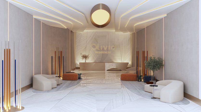 Un hall d'entrée moderne et élégant avec des sièges moelleux, un éclairage d'ambiance aux motifs géométriques et un mur central portant le nom « Olivia Residences » en lettres dorées – un investissement idéal à Dubaï