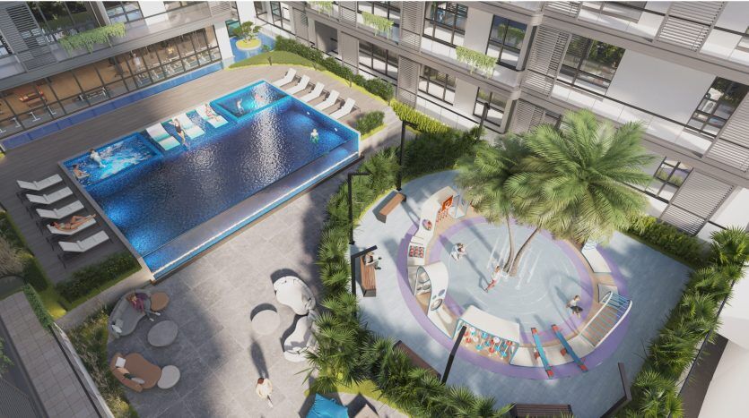 Vue aérienne d'une luxueuse zone de loisirs extérieure à Dubaï comprenant une grande piscine et une piscine séparée pour enfants entourée de palmiers, de chaises longues et d'une architecture moderne.