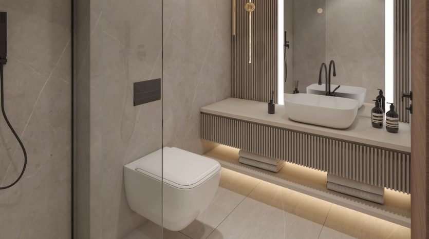 Salle de bain moderne dans une villa de Dubaï comprenant des toilettes murales, une double vasque avec vasques, de grands miroirs et un éclairage d'ambiance sous les armoires. Les tons neutres et les lignes épurées créent un look contemporain.