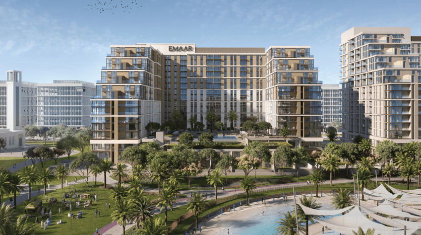 Développement urbain moderne mettant en valeur de grands appartements résidentiels et villas avec balcons, piscine, parcs paysagers et verdure abondante sous un ciel bleu clair. Des panneaux affichent le nom « EMAAR.