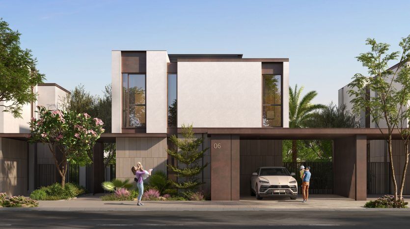 Villa moderne de deux étages à Dubaï avec de grandes fenêtres et un toit plat, comprenant une allée avec une voiture garée. Une femme prend une photo tandis qu'un homme se tient à proximité, entouré de verdure