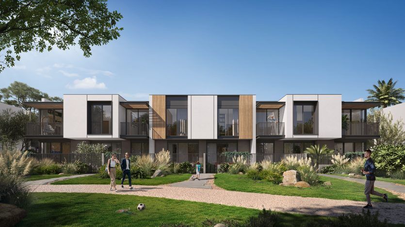Bâtiments résidentiels modernes à Dubaï avec de grandes fenêtres et balcons donnant sur un jardin bien entretenu où les résidents profitent d'activités de plein air.