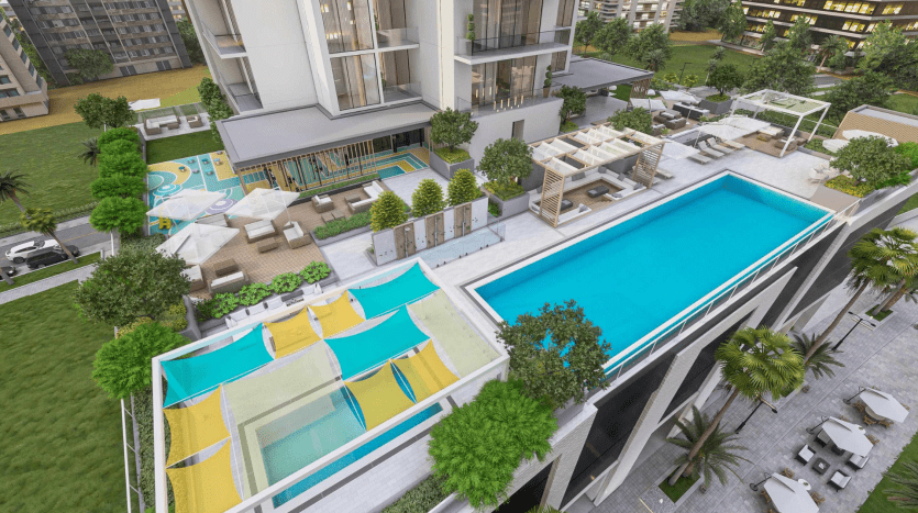 Vue aérienne d'une piscine moderne sur le toit flanquée de chaises longues et de jardins bien entretenus, avec une salle à manger extérieure adjacente et des bâtiments de villas résidentielles à Dubaï.