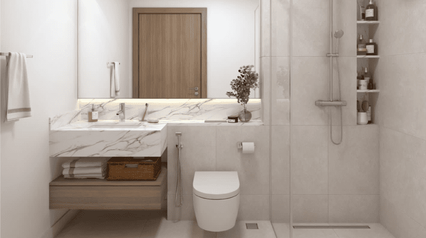 Une salle de bain moderne dotée d'un comptoir en marbre avec lavabo, grand miroir et douche à l'italienne. Les tons neutres dominent l'espace, accentués par des armoires en bois et une petite plante en pot.