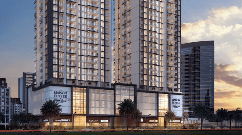 Un immeuble moderne de grande hauteur au crépuscule, avec des vitrines éclairées, dont la « Maison Elysée » et plusieurs boutiques au niveau de la rue, sur un ciel crépusculaire à Dubaï.