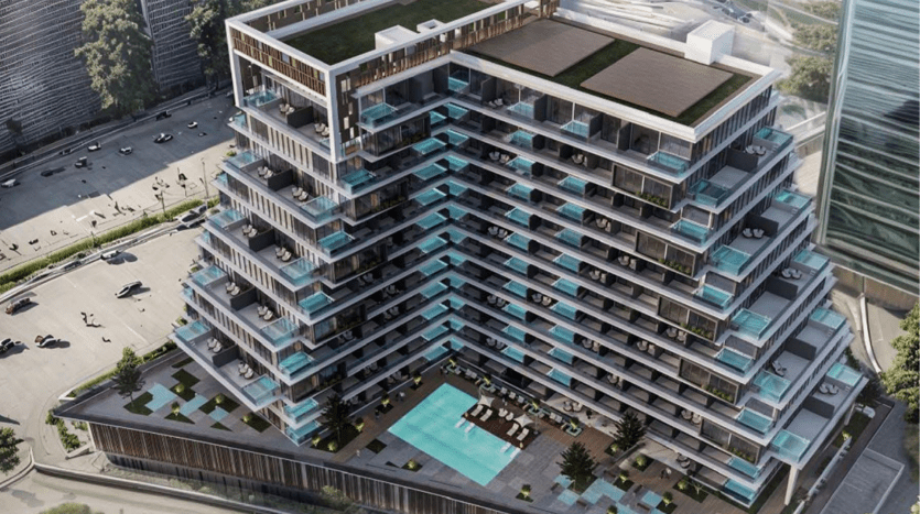 Vue aérienne d'un immeuble d'appartements moderne à plusieurs niveaux à Dubaï avec des balcons en verre, une grande piscine et des terrasses paysagées, entourées d'un quadrillage de rues avec des voitures.