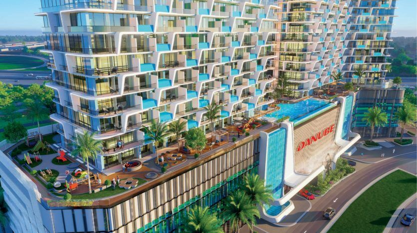 Un appartement de grande hauteur dynamique et moderne doté de grands balcons, d'un espace piscine coloré et d'un aménagement paysager luxuriant, situé à côté d'une route ensoleillée et d'espaces verts.