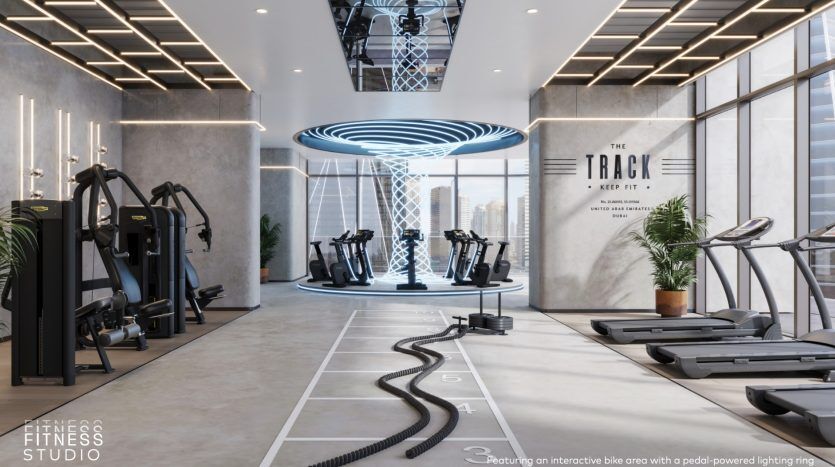 Intérieur d'un studio de fitness moderne avec tapis roulants, vélos d'exercice, équipements de musculation et un plafonnier bleu distinctif. Un éclairage élégant et un sol marqué de lignes de rail améliorent l'ambiance. Parfaitement adapté pour une villa haut de gamme à Dubaï.