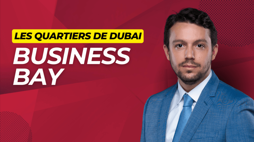 Un homme confiant vêtu d'un costume bleu se tient devant un fond rouge avec le texte « Les Quartiers de Dubai BUSINESS BAY appartement dubai.
