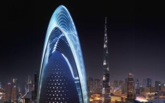 Paysage urbain nocturne avec un gratte-ciel incurvé et éclairé de manière unique au premier plan et le Burj Khalifa visible en arrière-plan sous un ciel étoilé, capturé par une agence immobilière de Dubaï.