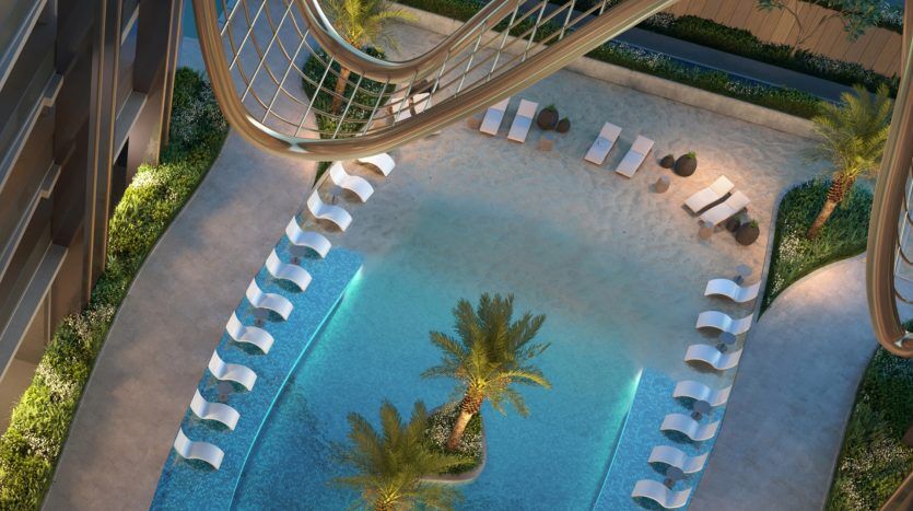 Vue aérienne d'une piscine luxueuse au crépuscule à Dubaï, avec des chemins courbes, des chaises longues confortables, des palmiers et un éclairage ambiant.