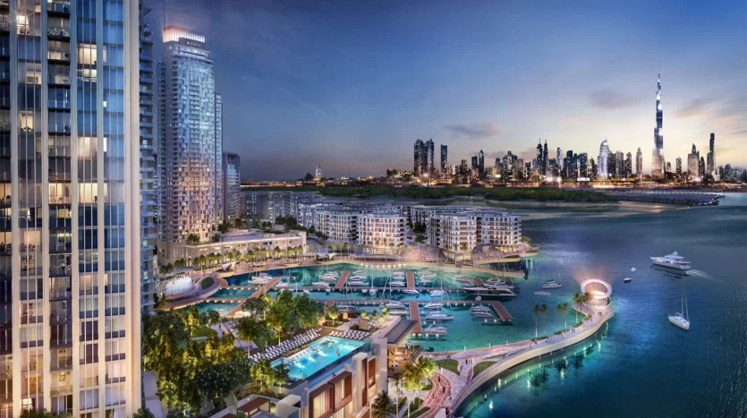 Une vue panoramique sur les toits d'une ville côtière au crépuscule, avec des immeubles de grande hauteur modernes, une marina avec des bateaux et des zones résidentielles luxueuses de l'immobilier Dubaï avec piscines.