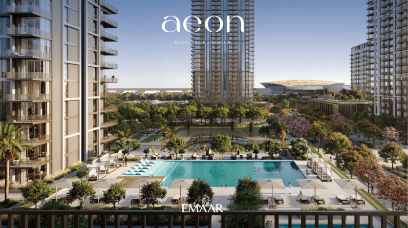 Complexe résidentiel luxueux à Dubaï avec des immeubles de grande hauteur modernes donnant sur une grande piscine centrale entourée d'une verdure luxuriante et d'espaces de détente, avec les logos « AEON » et « EMAAR » visibles.