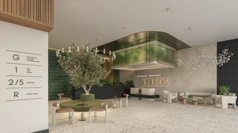 Hall d'entrée d'une villa moderne à Dubaï avec un olivier au centre, un mobilier vert et or et une décoration élégante. Un panneau sur la gauche répertorie les différents étages et commodités.