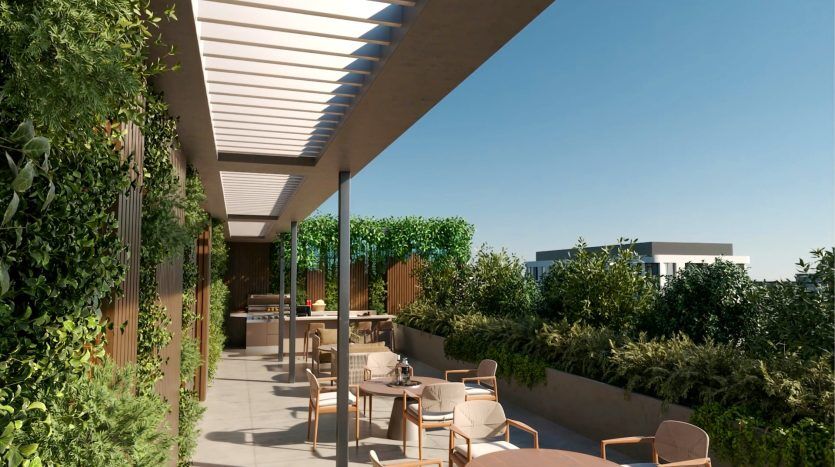 Une terrasse extérieure moderne comprenant un coin repas avec un mobilier élégant, entourée d'une verdure luxuriante, sous un toit à lattes élégant avec un ciel dégagé au-dessus dans un appartement à Dubaï.