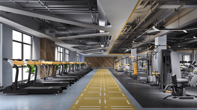 Intérieur de salle de sport moderne dans un appartement de Dubaï comprenant des rangées de tapis roulants, des appareils de musculation et une piste de course marquée, avec un mélange d'accents en bois et de plafond exposé.