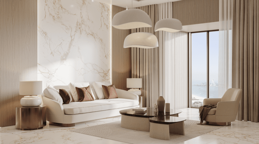 Salon luxueux dans un appartement de Dubaï avec un canapé blanc agrémenté d'oreillers rouges, de murs en marbre, de lampes élégantes et de grandes fenêtres donnant sur la mer.