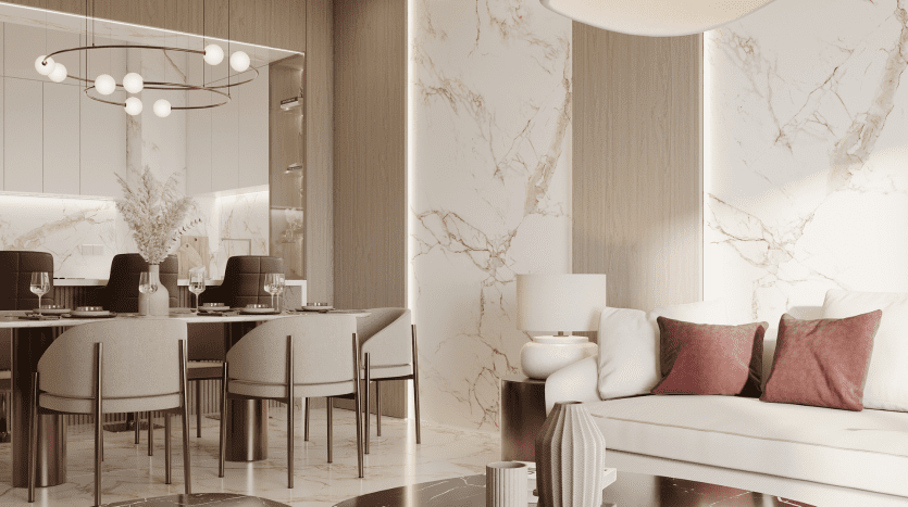 Salon moderne avec un canapé blanc orné d'oreillers rouges, adjacent à une salle à manger dotée d'une table en bois sombre et de chaises grises, le tout entouré de murs en marbre et de luminaires élégants dans une luxueuse villa de Dubaï.