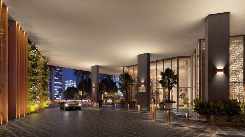 Entrée d'hôtel élégante au crépuscule à Dubaï, dotée de lumières brillantes, d'un design moderne avec des jardins verticaux et des piliers élégants, menant à une porte d'entrée vitrée avec une voiture garée à l'extérieur.