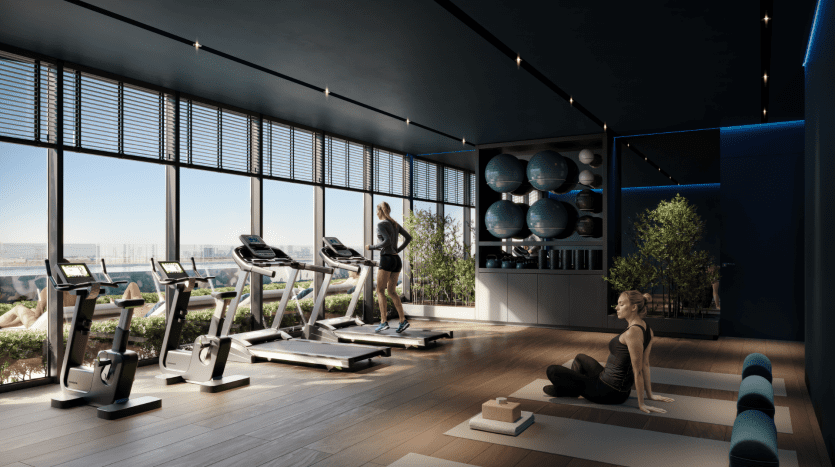 Intérieur de salle de sport moderne avec des individus faisant de l'exercice ; un courant sur un tapis roulant et un autre faisant du yoga. La salle de sport dispose de grandes fenêtres avec vue sur la ville de Dubaï, de touches bleues et de divers équipements de fitness.