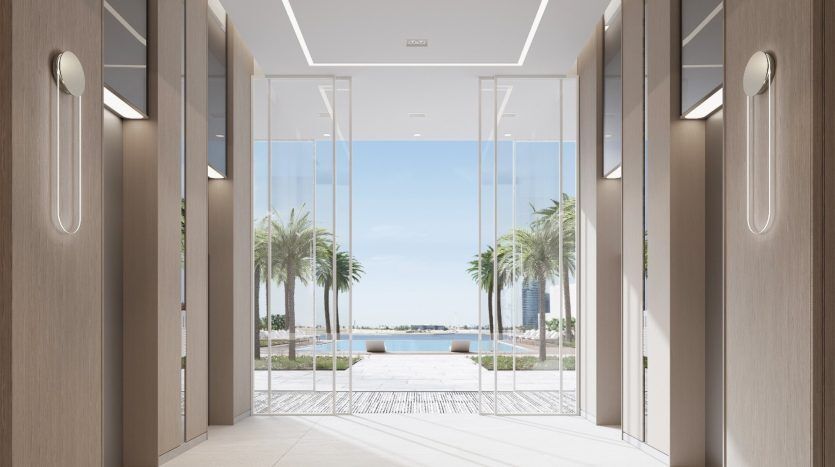 Hall d'ascenseur moderne au design élégant, doté de deux portes d'ascenseur flanquées de murs réfléchissants, menant à une porte vitrée donnant sur une vue sereine en bord de mer dans une villa de Dubaï.