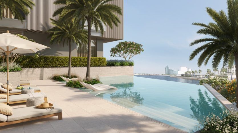 Un bord de piscine luxueux avec des chaises longues, des palmiers et une piscine à débordement dans une villa de Dubaï surplombant un paysage côtier ensoleillé.
