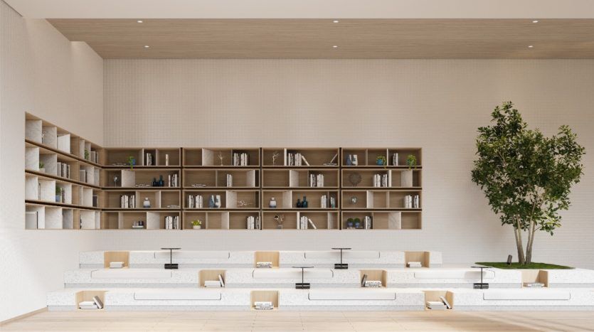Intérieur de bibliothèque moderne comprenant une grande étagère en bois avec divers objets et livres, des tables blanches avec des chaises et un arbre intérieur, dans une villa spacieuse et bien éclairée à Dubaï.