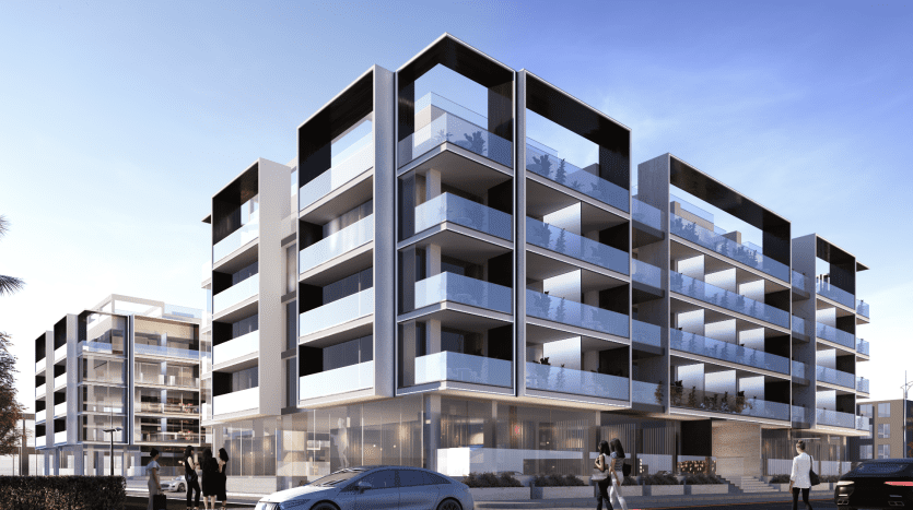 Immeubles d'appartements modernes à plusieurs étages avec de vastes balcons en verre sous un ciel clair à Dubaï. Les gens marchent et une voiture est garée devant.