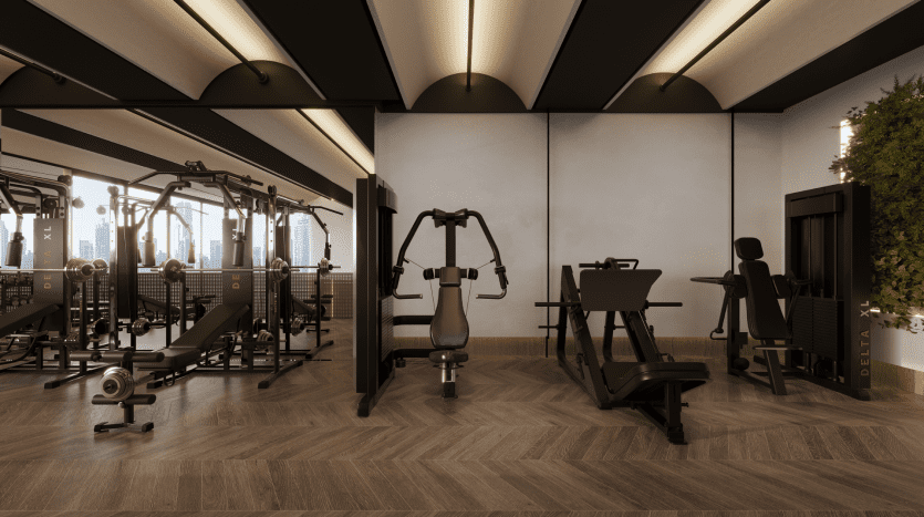 Intérieur de salle de sport moderne avec divers équipements d'exercice, notamment des appareils de musculation et des appareils de cardio-training, sur fond de grandes fenêtres donnant sur le paysage urbain de Dubaï.