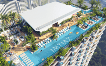 Vue aérienne d'une luxueuse piscine sur le toit d'un immeuble de grande hauteur à Dubaï, entourée de plantes tropicales, avec des gens bronzant et nageant.