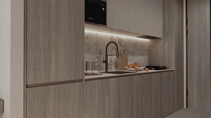 Intérieur de cuisine moderne dans une villa de Dubaï comprenant des armoires en bois, un dosseret en marbre et des appareils électroménagers intégrés avec éclairage ambiant mettant en valeur le design élégant. Un bol d'oranges ajoute une touche de couleur.