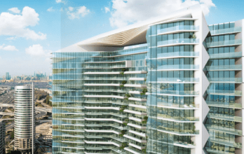 Gratte-ciel moderne aux lignes architecturales fluides et aux vastes façades vitrées, surplombant un paysage urbain avec des autoroutes et des bâtiments lointains sous un ciel clair à Dubaï.