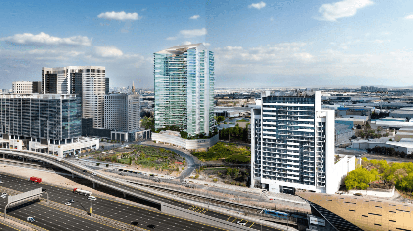 Un paysage urbain de jour composé d'immeubles de grande hauteur modernes, d'un gratte-ciel en verre incurvé, d'autoroutes très fréquentées et d'espaces verts luxuriants, sur fond de collines lointaines et d'un ciel partiellement nuageux. Cette vue est idéale à découvrir grâce à une agence immobilière Dubaï.