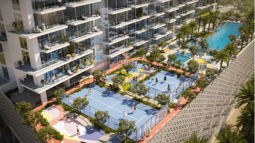 Aerial view of a luxury apartment complex in Dubai featuring several balconies, a large swimming pool and adjacent colorful basketball courts with players engaged in a match.