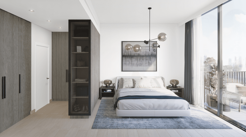 Chambre moderne dans un appartement de Dubaï comprenant un grand lit avec des draps bleus, du parquet, des baies vitrées et une élégante porte vitrée ouverte menant à un balcon. La décoration comprend une suspension et un mobilier minimaliste.
