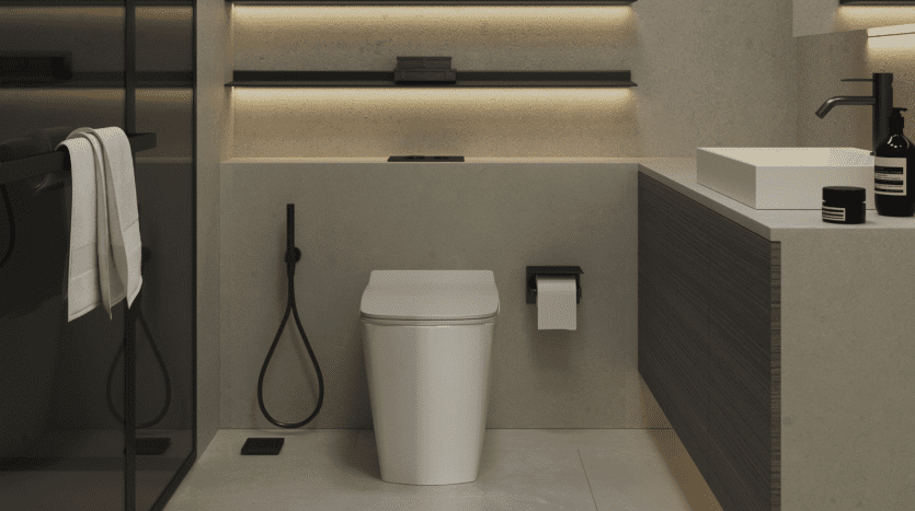 Intérieur de salle de bains moderne dans une villa de Dubaï avec un éclairage tamisé, comprenant des toilettes minimalistes, des armoires en bois et des luminaires noirs élégants contre un mur de sable texturé.