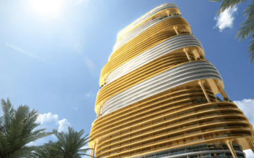 Un gratte-ciel futuriste et tourbillonnant doré se dresse sous un ciel clair, entouré de palmiers luxuriants, avec un jet laissant une traînée dans le ciel au-dessus. Ce monument est l'une des principales attractions immobilières de Dubaï.
