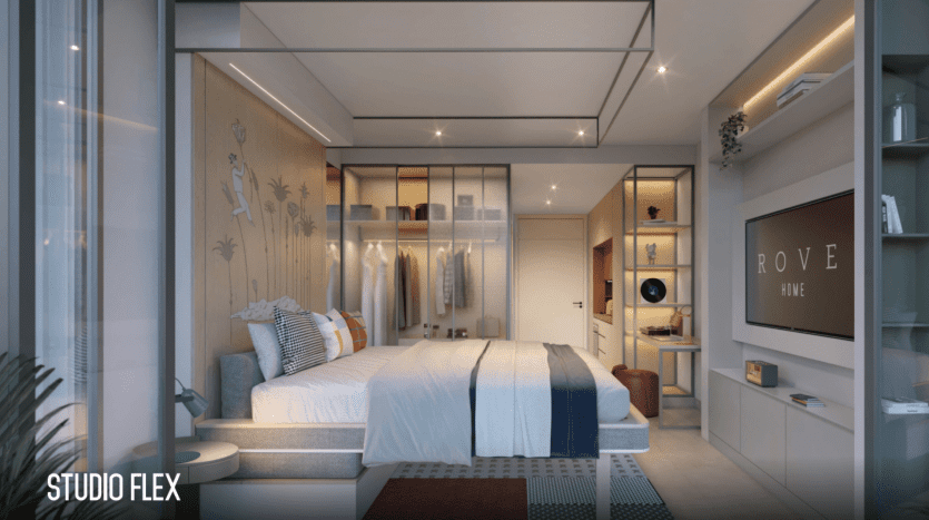 Un studio moderne à Dubaï comprenant un lit confortable avec une literie bleue et blanche, des accents en bois, une décoration élégante, des placards intégrés et un éclairage ambiant. Une grande fenêtre apporte de la lumière naturelle.